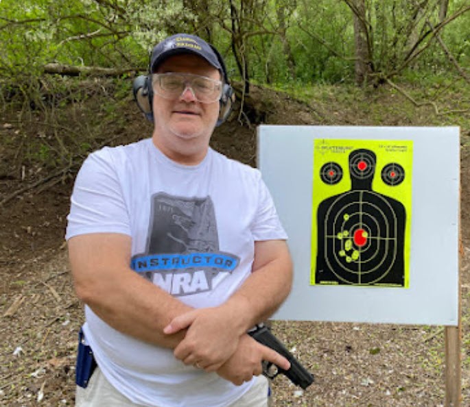 Gary Wolf standing next to range target.
